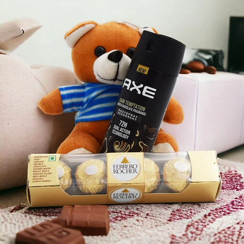 Axe deodorant stick and Ferrero Rocher chocolate on a couch with a teddy bear in the background.