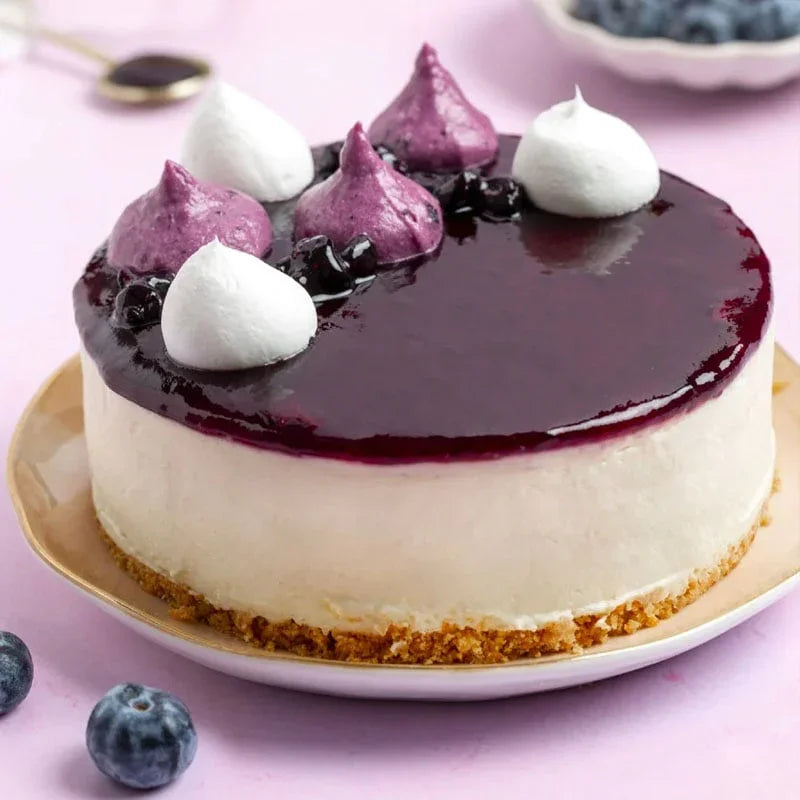 Blueberry cheesecake with biscuit base, glossy blueberry topping, white and purple meringue