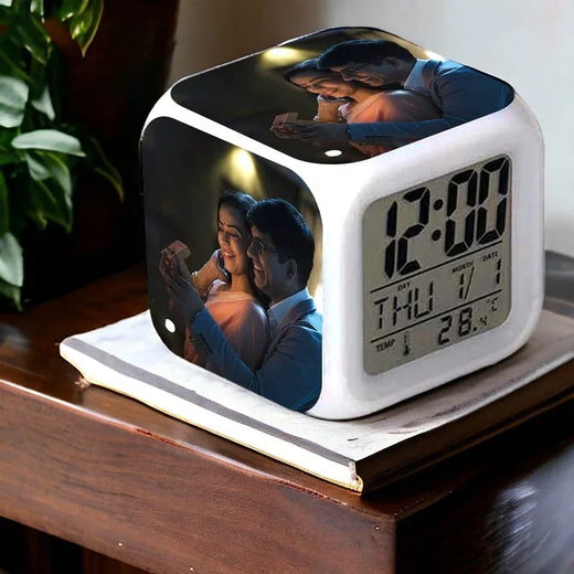 Cube-shaped digital clock with photo display on a wooden surface