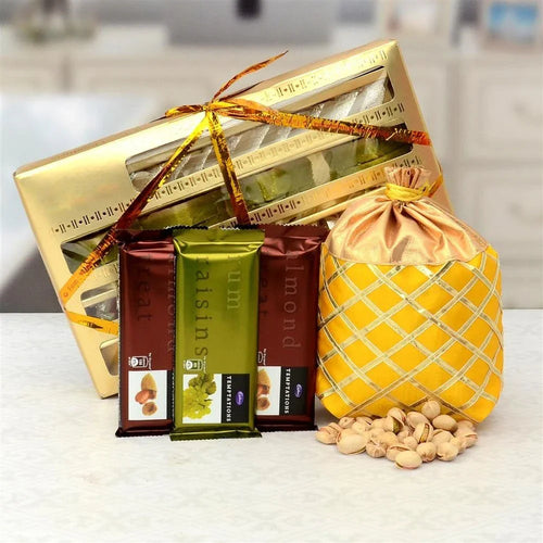 Gift basket with colorful sweets items including a dry fruits bag on a white surface.