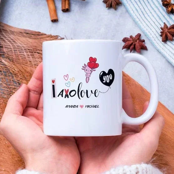 White mug with personalized design held by a hand on a wooden surface with star anise and cinnamon sticks.