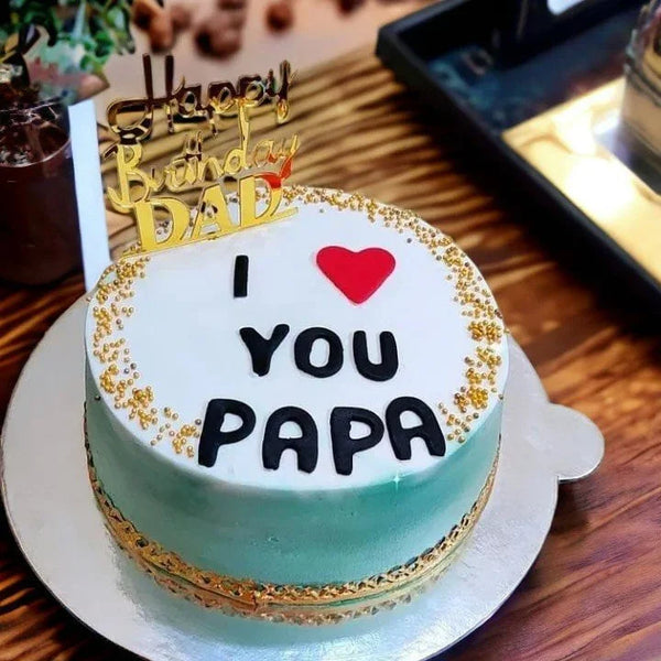 Birthday cake with 'I ❤️ YOU PAPA' text on a wooden table.
