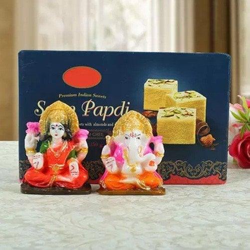 Indian sweets box of Soan Papdi with small Lakshmi and Ganesha idols on a table