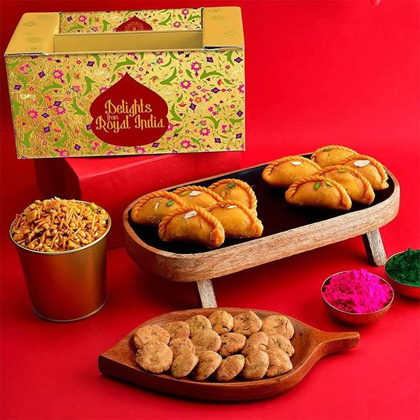 Assorted snacks on a wooden tray with a decorative box labeled 'Delights of Royal India' on a red background.