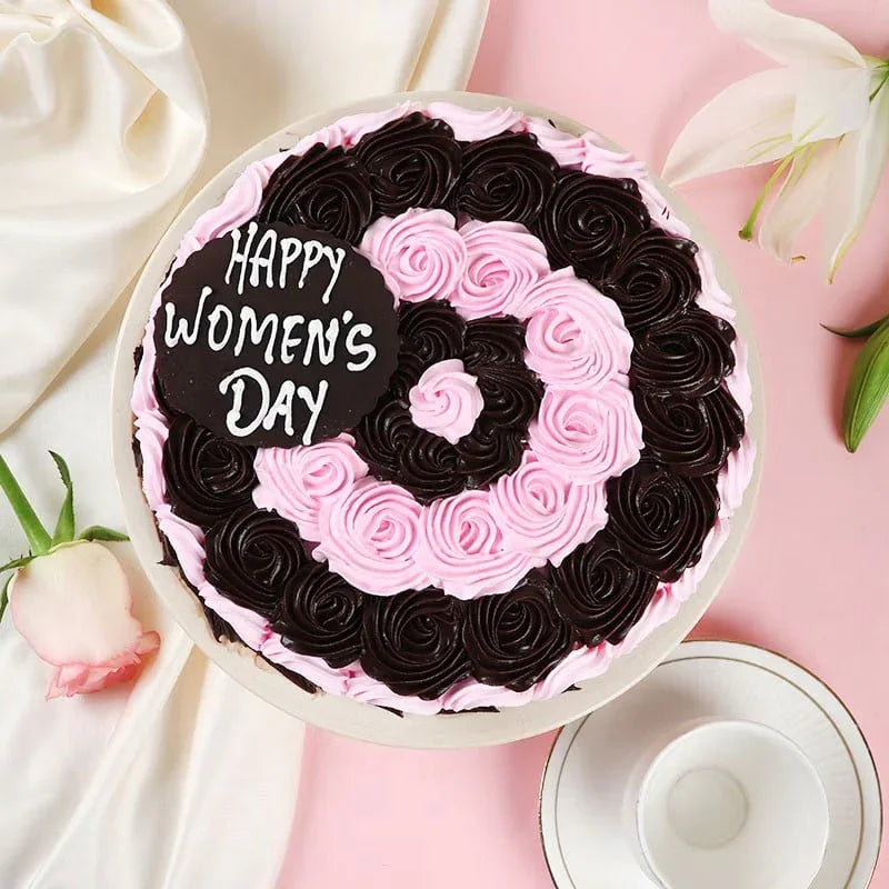 Decorative cake with pink and black icing on a pink background with flowers