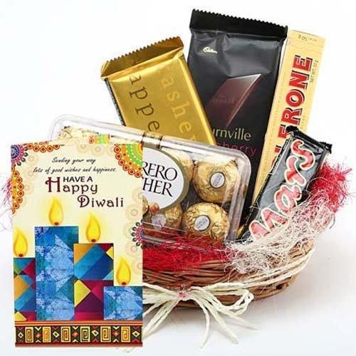 Gift basket with chocolates, candy bars, and a Diwali card on a white background
