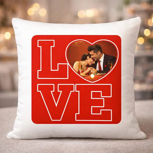 White pillow with a red 'LOVE' design featuring a couple in a heart shape