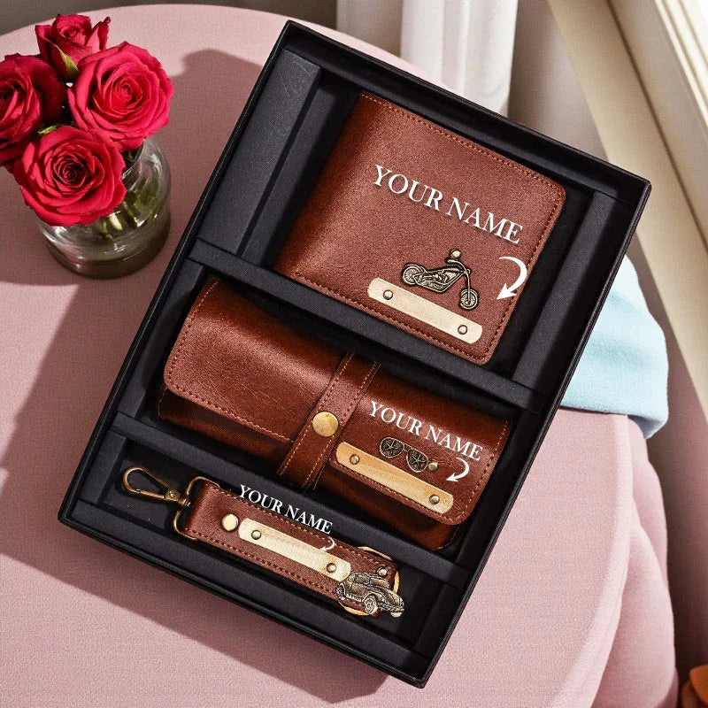 Brown leather wallet and keychain set with 'Your Name' engraving on a pink surface with red roses.