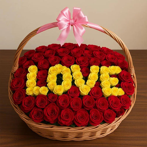 Basket of red and yellow roses spelling 'LOVE' with a pink bow 