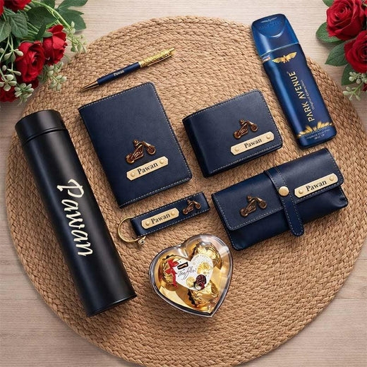 Collection of branded items including a black tumbler, blue wallets, and a decorative heart-shaped object on a woven mat.