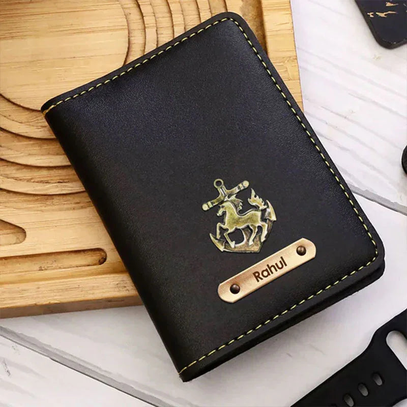 Black leather wallet with gold emblem and nameplate on a wooden surface