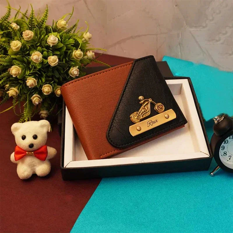 Brown and black leather wallet with decorative emblem in a box, surrounded by a teddy bear, flowers, and alarm clock.