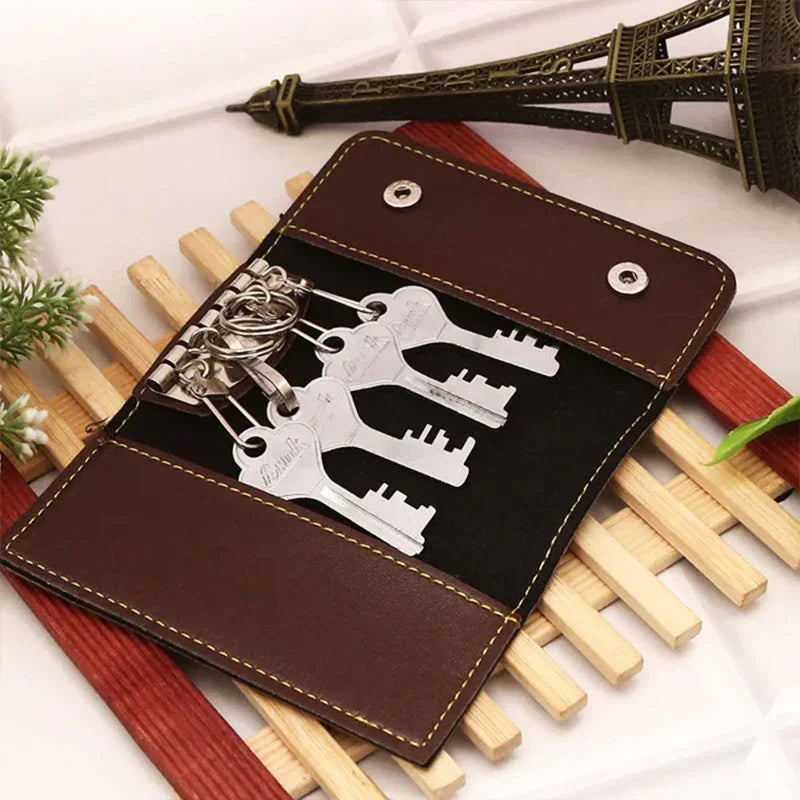 Brown leather key organizer with multiple keys on a white surface with decorative elements.