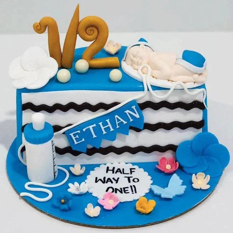 Baby-themed birthday cake with 'Ethan' on a white background