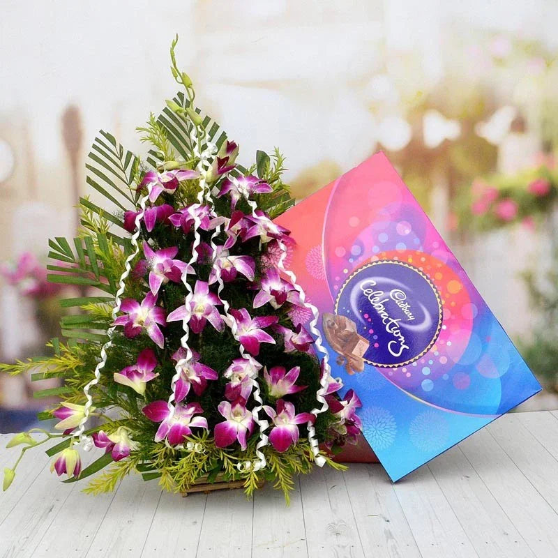 Bouquet of purple orchids with a Cadbury chocolate box on a blurred background