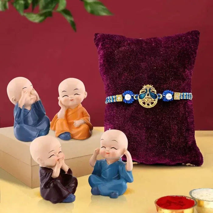 Four small monk figurines with a decorative belt on a purple pillow against a red background.