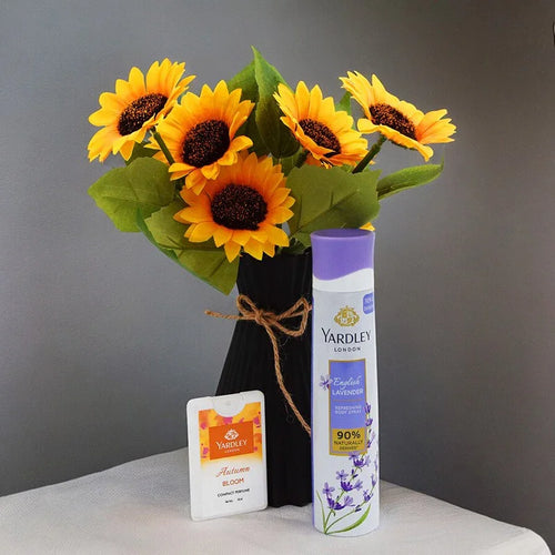 Yardley London products including a bottle and a pouch with sunflowers in a vase on a gray background