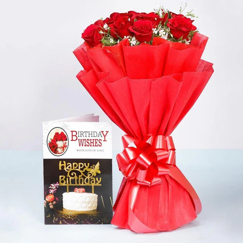 Bouquet of red roses wrapped in red paper with a birthday card on a light gray background