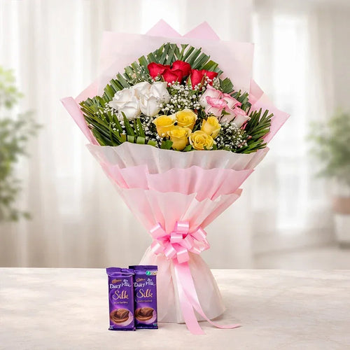 Bouquet of flowers with pink ribbons and two Dairy Milk Silk chocolate bars on a white surface.