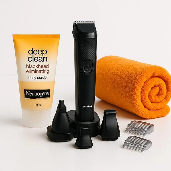 Grooming kit with trimmer, Neutrogena face scrub, attachments, and orange towel on white background
