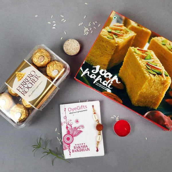 Raksha Bandhan gift set with rakhi, Ferrero Rocher chocolates, soan papdi, rice, and diya.