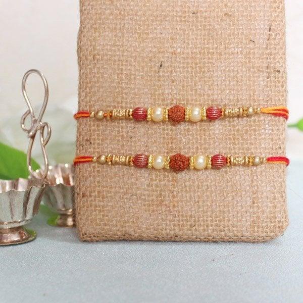 Traditional rakhi set with rudraksha, beads and red thread on a jute background, festive decor