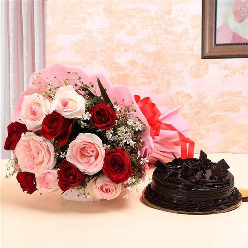 Bouquet of red and pink roses with a chocolate cake on a decorative background