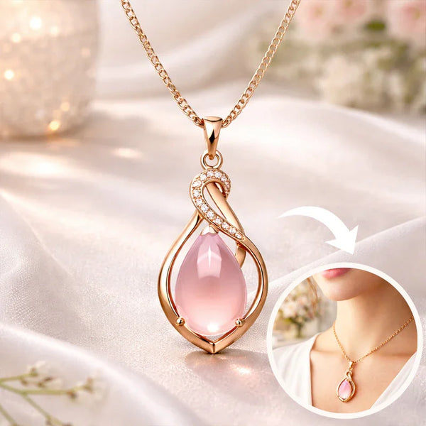Pink teardrop pendant necklace on a soft fabric background