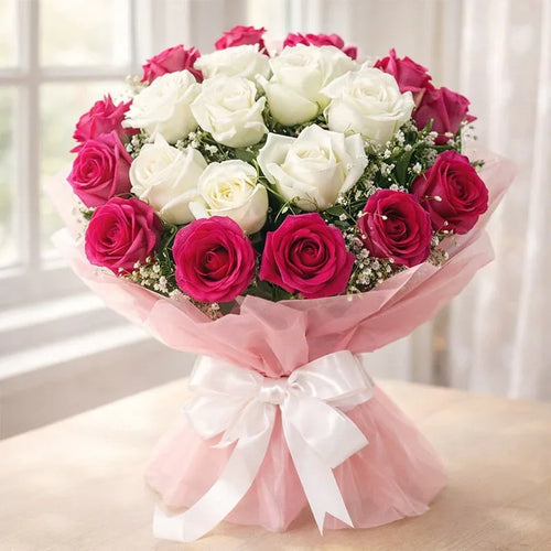 Bouquet of pink and white roses wrapped in pink paper with white ribbon, perfect for gifting