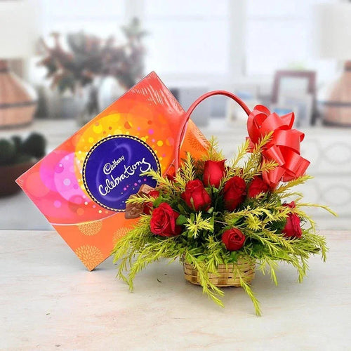 Bouquet of red roses with a Cadbury chocolate box on a blurred background