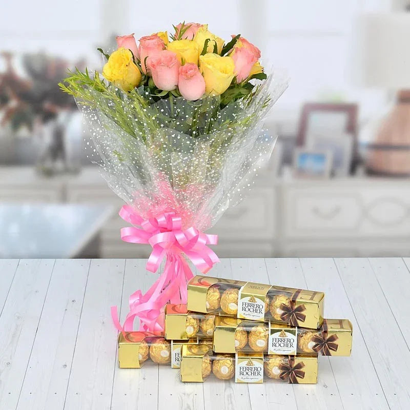 Bouquet of flowers with a pink ribbon and Ferrero Rocher chocolates on a wooden surface.