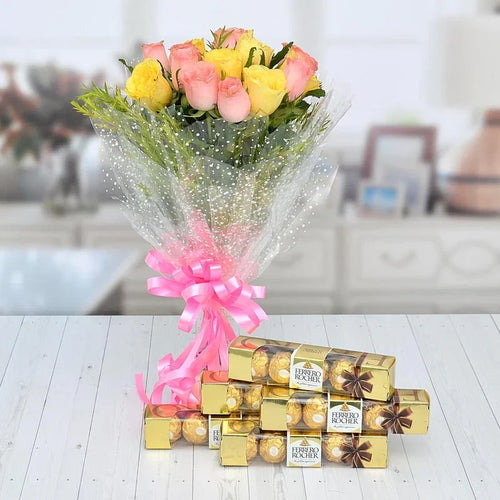 Bouquet of flowers with a pink ribbon and Ferrero Rocher chocolates on a wooden surface.