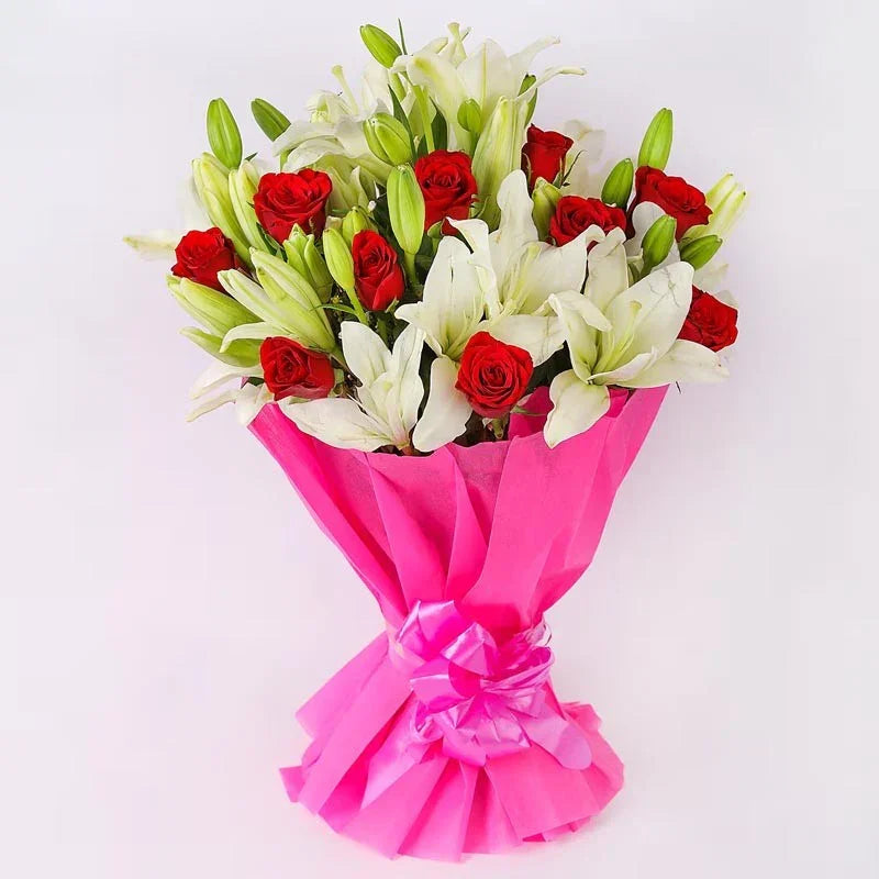 Bouquet of red roses and white lilies wrapped in pink paper on a white background