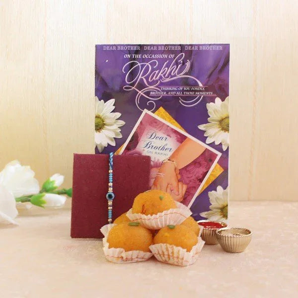 Rakhi gift set with greeting card, sweets, rakhi thread, and roli chawal cups for brother