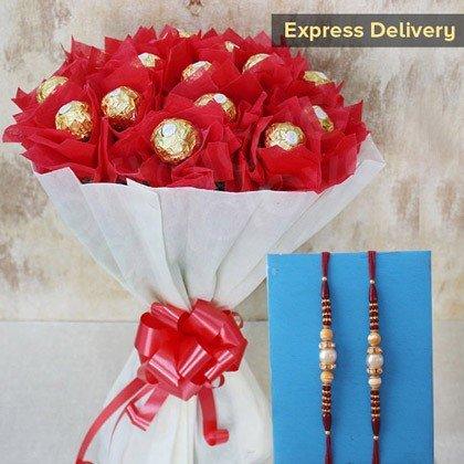 Bouquet of red roses with gold Ferrero Rocher chocolates and a pair of Rakhi 