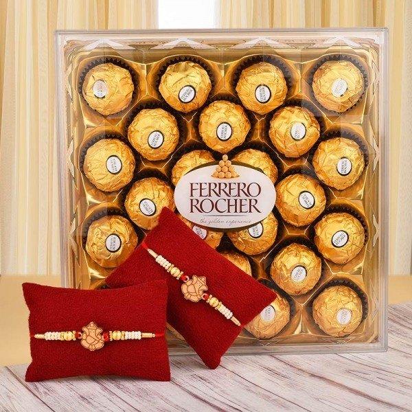 Box of Ferrero Rocher chocolates with two decorative rakhi bracelets on red cushions