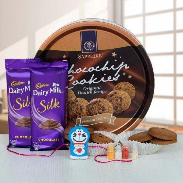 Gift combo with choco chip cookies, Dairy Milk Silk chocolates, cartoon rakhi, and roli chawal.