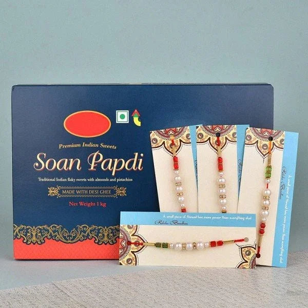 Box of Soan Papdi sweets with five decorative rakhi bracelets displayed in front