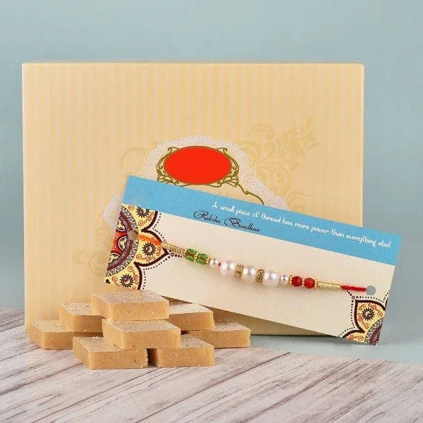 Colorful rakhi with pearls and beads, Indian sweets, and gift box for Raksha Bandhan