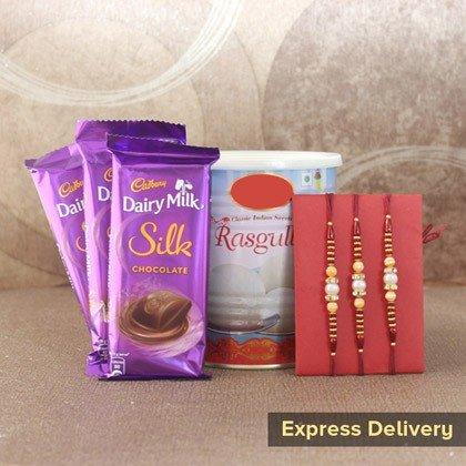 Rakhi gift set with Dairy Milk Silk chocolates, rasgulla tin, and traditional rakhis