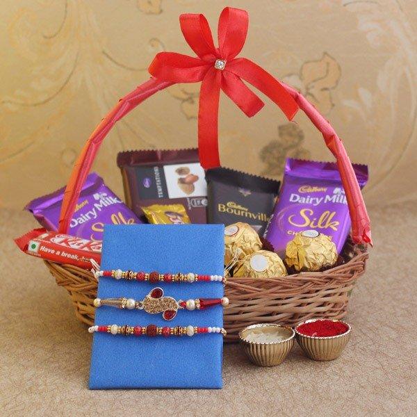 Rakhi gift basket with chocolates, three decorative rakhis, and roli chawal cups
