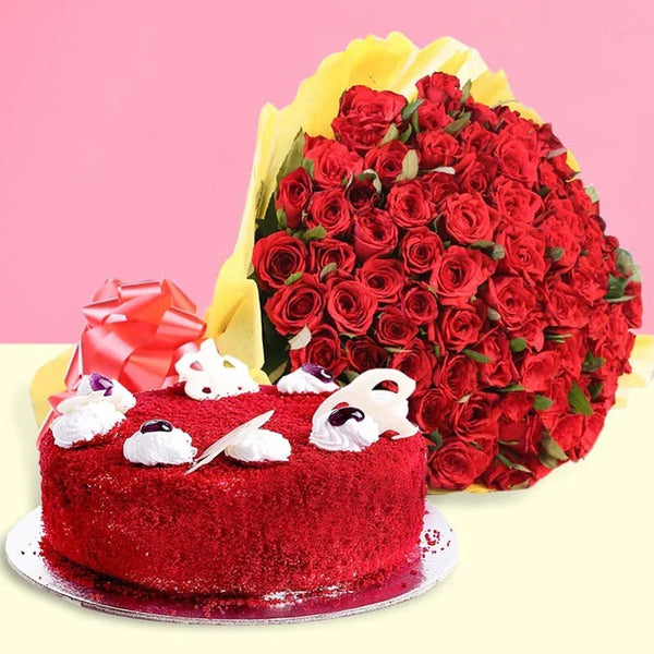 Red velvet cake with white decorations and a large bouquet of red roses on a pink background