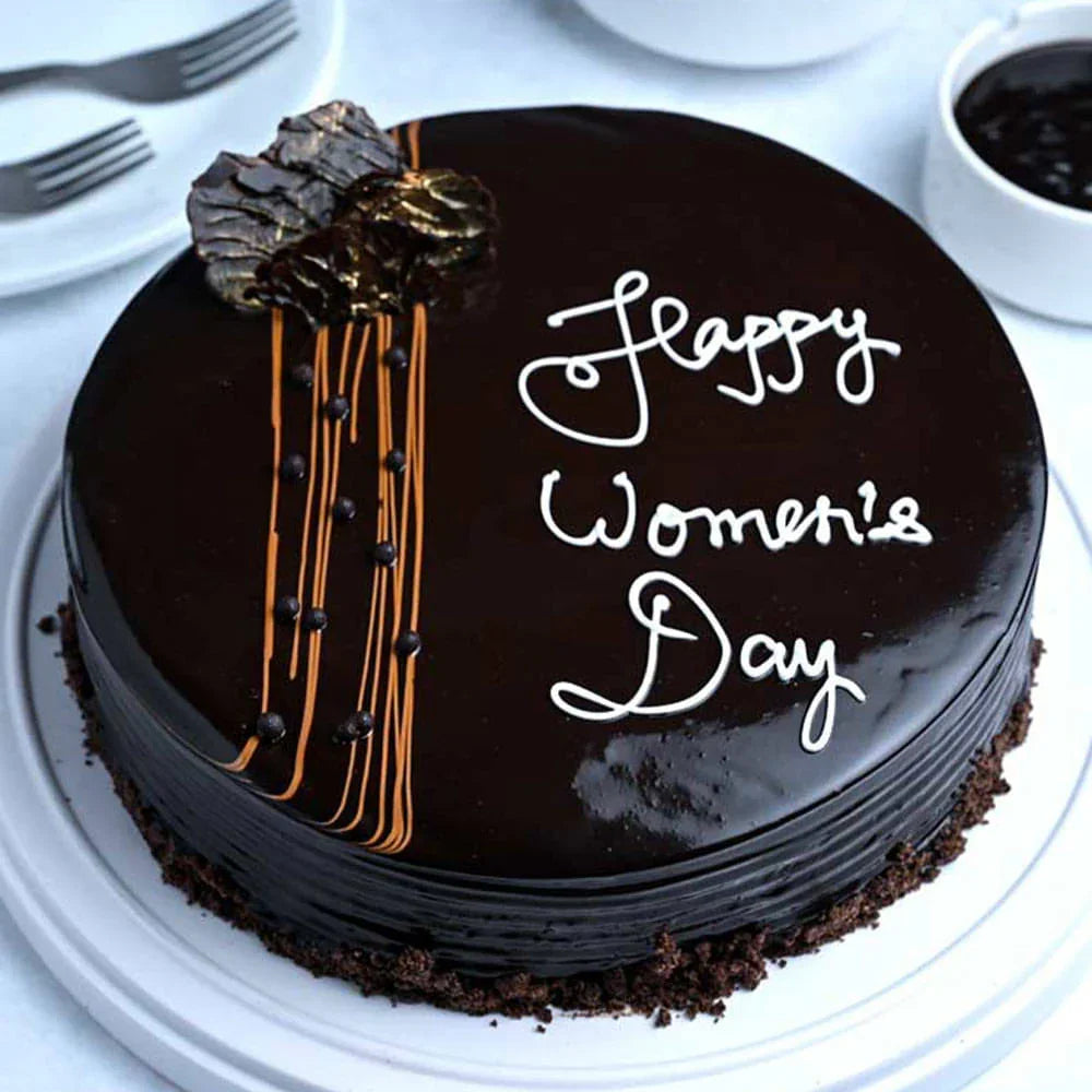 Chocolate cake with 'Happy Women's Day' text on a white plate