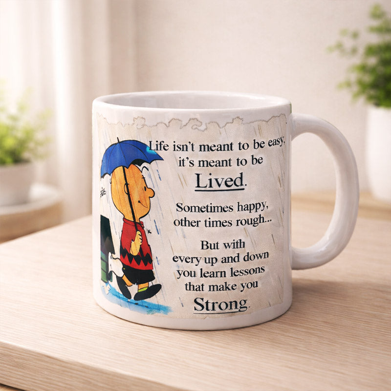 Mug with a cartoon character and motivational quote on a wooden surface