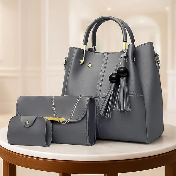 Gray handbag with tassel and matching pouch on a round table