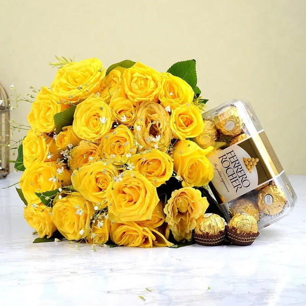 Bouquet of yellow roses with a box of Ferrero Rocher chocolates on a light background