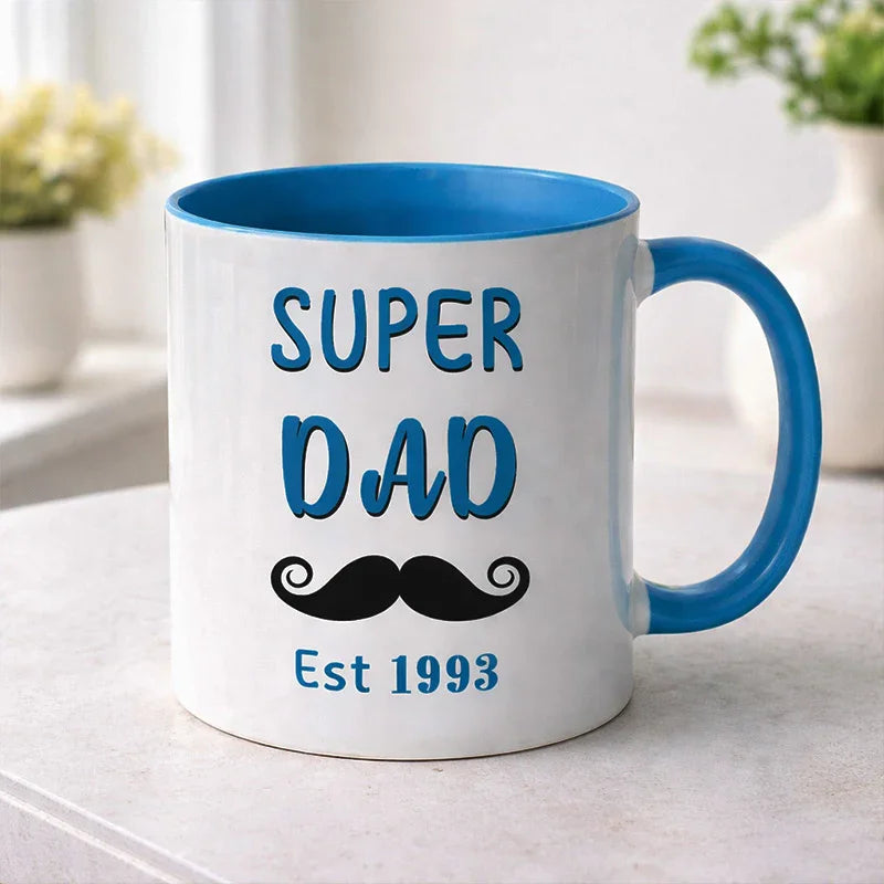 Mug with 'Super Dad Est 1993' text and mustache graphic on a light surface.
