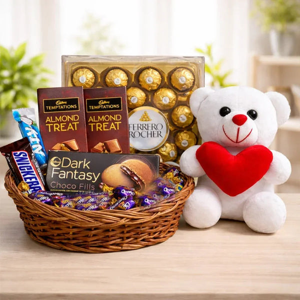 Gift hamper with assorted chocolates, Ferrero Rocher, and a white teddy bear holding a heart.
