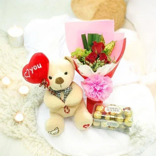 Gift set with teddy bear holding a heart, red rose bouquet, and Ferrero Rocher chocolates