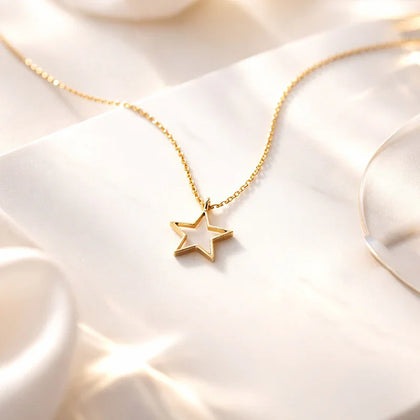 Gold necklace with a star pendant on a soft white fabric background